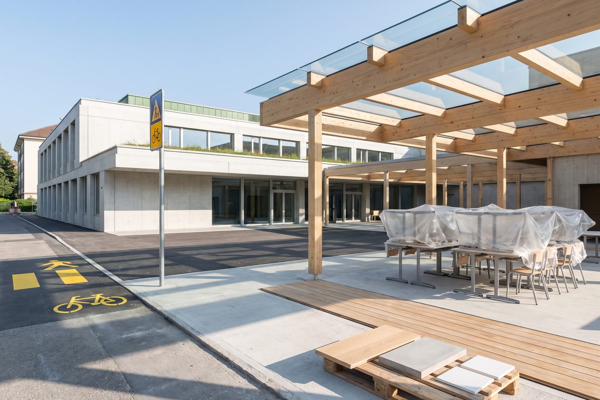 Façade d'un nouveau groupe scolaire genevois voisin du bâtiment historique du Cénacle, illustration générée